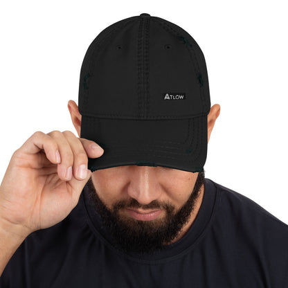 Distressed dad hat in black with ATLOW logo being adjusted by a man, showcasing premium streetwear style.